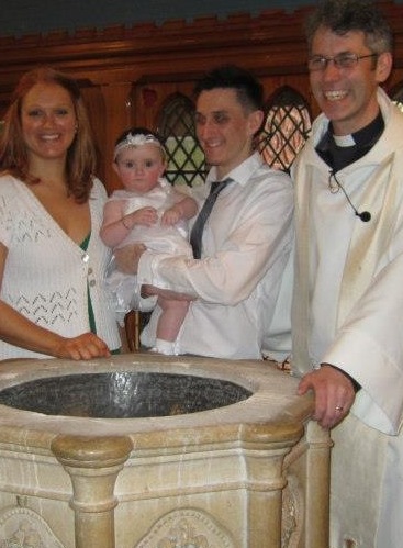 image of parents baby and vicar at the font